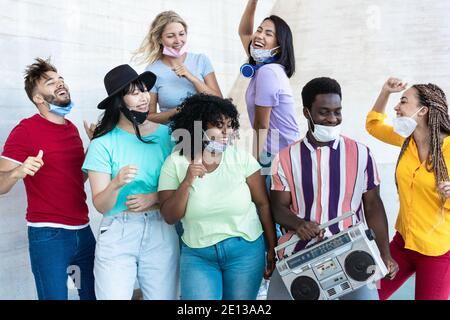 Multirassische Freunde tanzen zu Musik mit Boombox Stereo im Freien mit Masken unter Chins - Fokus auf schwarzen Mann Stockfoto