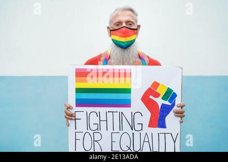 Hipster Gay Senior Mann mit Regenbogen Maske halten Banner an lgbt-stolz – Fokus auf Gesicht Stockfoto