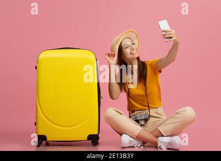 Hübsche junge Frau, die Selfie mit dem Gepäck nimmt Stockfoto