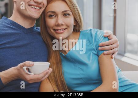 Schöne glückliche rothaarige Frau lächelnd, Kuscheln mit ihrem Freund im Café. Kurzer Schuss eines fröhlichen Mannes umarmt seine schöne Frau, e Stockfoto