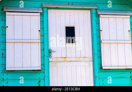 Farbenfrohe Details einer hellen grünen und weißen Strandhütte auf der Westward Ho Seafront mit Blick auf den Strand und Torridge Mündung. Westward Ho!, Devon, Englan Stockfoto