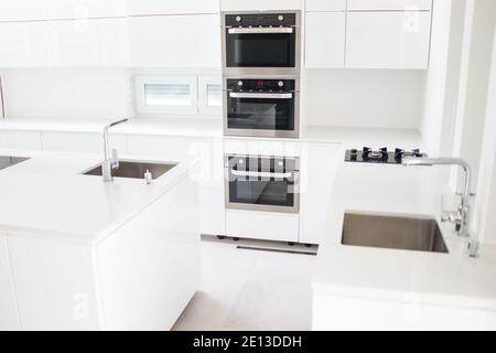 Weiß organisierte Küche mit modernen Elementen in einer Wohnung. Hochwertige Fotos Stockfoto