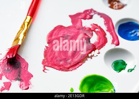 Malen Sie auf der Palette, Streifen aus dem Mischen von hellen und dunklen Schattierungen. Mischen von Farbe vor dem Malen eines Bildes. Stockfoto