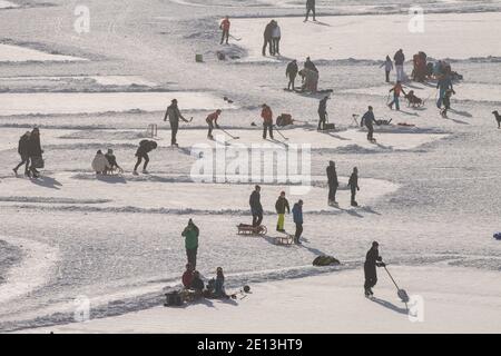 Spitzingsee, Deutschland. Januar 2021. Touristen und Einheimische tummeln sich in der Sonne über der Wolkenlinie am gefrorenen Spitzingsee, der 1084 Meter über dem Meeresspiegel liegt. Kredit: Peter Kneffel/dpa/Alamy Live Nachrichten Stockfoto