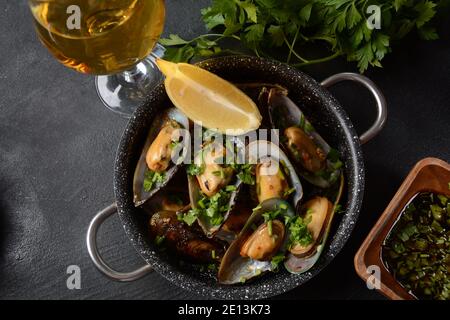 Klassische französische Mahlzeit Moules marinière Marinara Muscheln mit Knoblauch, Sauce, Zitrone und Petersilie. Stockfoto