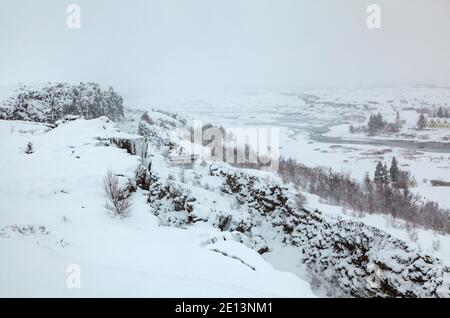 Fast monochromatischer Blick über den Thingvellir Nationalpark Rifttal vom Informationszentrum im Winter, Südwesten Islands während eines Schneesturms Stockfoto