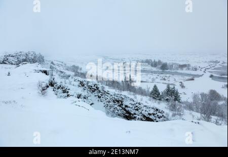 Fast monochromatischer Blick über den Thingvellir Nationalpark Rifttal vom Informationszentrum im Winter, Südwesten Islands während eines Schneesturms Stockfoto