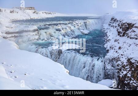 Gullfoss Schlucht und Hvita Fluss abgestufte Kaskaden und Wasserfälle, eine der beliebtesten Touristenattraktionen in Island, gefroren mit Eiszapfen im Winter Stockfoto