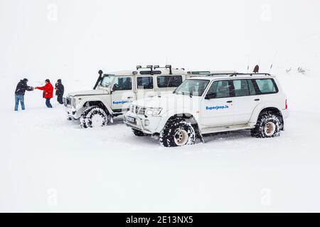 White Land Rover Defender 4v4 4WD Fahrzeuge in schweren geparkten Schnee auf einem touristischen Ausflug in Island Stockfoto