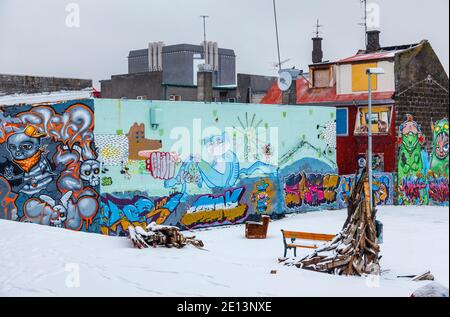 Farbenprächtiges Graffiti-Spray an den Wänden in einer heruntergekommenen Gegend der Innenstadt von Reykjavik, der Hauptstadt Islands, mit einer Schneedecke im Winter Stockfoto