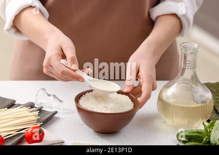 Frau bereitet Sauce mit Reisessig in der Küche Stockfoto