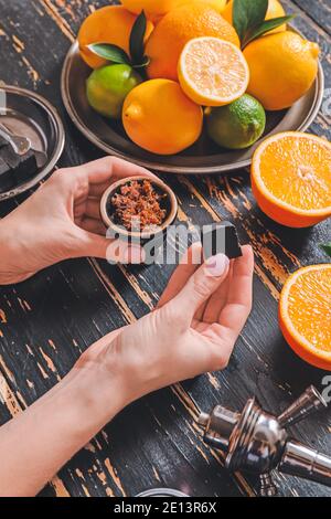 Frau bereitet Shisha Schüssel für das Rauchen am Tisch Stockfoto