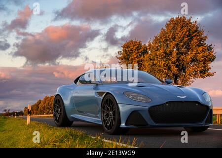 Aston Martin DBS superleggera auf einer malerischen Straße bei Sonnenuntergang Stockfoto