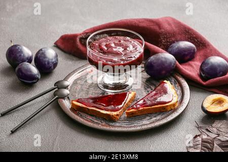 Komposition mit köstlicher hausgemachter Pflaumenmarmelade auf dem Tisch Stockfoto