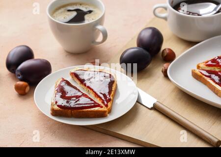 Brotscheiben mit köstlicher hausgemachter Pflaumenmarmelade auf dem Teller Stockfoto