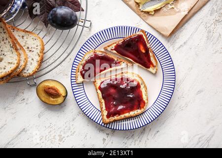 Brotscheiben mit köstlicher hausgemachter Pflaumenmarmelade auf dem Teller Stockfoto