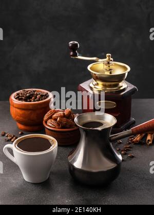 Cezve, Mühle und Tasse Kaffee auf dem Tisch Stockfoto