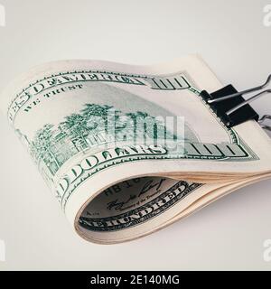 Rolle von hundert amerikanischen Dollar Nahaufnahme auf einem grauen Hintergrund. Nahaufnahme, freier Platz für Bildunterschriften und Text. Stockfoto