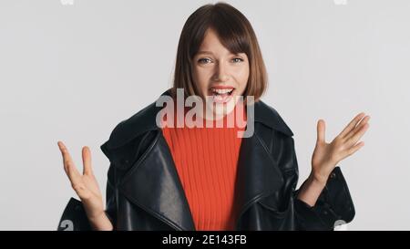 Ziemlich fröhlich Brünette Mädchen mit bob Haar in lässig gekleidet Tragen Gefühl aufgeregt kann nicht glauben, es glücklich über Weißer Hintergrund Stockfoto