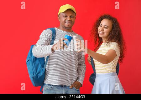 Afroamerikanisches Paar mit Soda auf farbigem Hintergrund Stockfoto