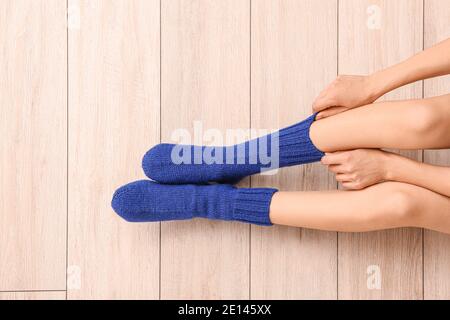 Junge Frau, die zu Hause Socken anziehen Stockfoto