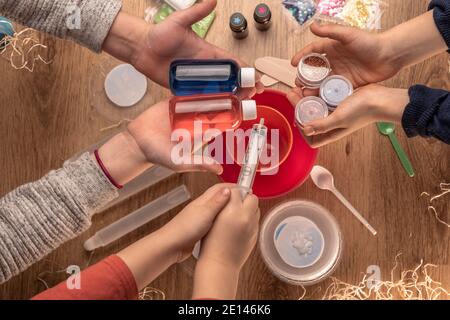 Kinder Hände machen Schleim Spielzeug zu Hause. Schleim machen. Zutaten und Komponenten mischen, Kinder Kreativität Indoor Urlaub Stockfoto