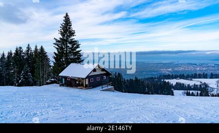 Ferienhaus in den österreichischen Bergen mit Blick auf den Bodensee. Verschneite Landschaft. Ferienhaus in Ammenegg, verschneite Landschaft mit Bodensee Stockfoto