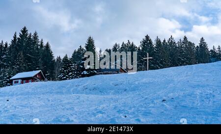 Ferienhaus in den österreichischen Bergen mit Blick auf den Bodensee. Verschneite Landschaft. Ferienhaus in Ammenegg, verschneite Landschaft mit Bodensee Stockfoto