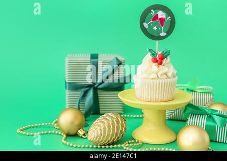 Dessertständer mit leckeren Weihnachts-Cupcake auf farbigem Hintergrund Stockfoto