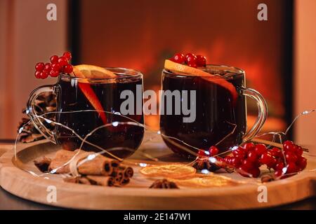 Tablett mit Gläsern leckerer Glühwein in der Nähe des Kamins Stockfoto