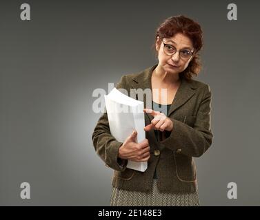 Oberlehrer hält Prüfungsergebnisse mit einem schweren Ausdruck Stockfoto