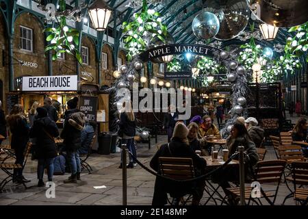 Weihnachtskäufer sitzen und nehmen sich einen gesellschaftlich distanzierten Kaffee in der Covent Garden Piazza während der Tier2 Coronavirus Lockdown Measures, London UK Stockfoto