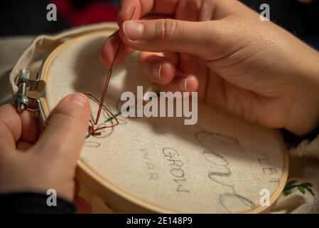 Nahaufnahme der Hände beim Sticken. Stockfoto