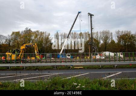 Langley, Slough, Berkshire, Großbritannien. November 2020. Die Modernisierung der M4 Smart Motorway wird in der Nähe der Anschlussstelle M4 nach Langley, Slough in Berkshire fortgesetzt. Derzeit gibt es Geschwindigkeitsbeschränkungen für die M4 von 50 mph, während die M4 zu einer digitalen Autobahn mit variablen Geschwindigkeitsbegrenzungen aufgerüstet wird. In Großbritannien wurden in den letzten fünf Jahren 35 Menschen auf Smart Motorways getötet, und viele Bewohner von Berkshire werden die M4 nicht mehr benutzen, sobald die Smart Motorway aus Sicherheitsgründen in Betrieb genommen wird, da die harte Schulter entfernt und durch zeitweise auftretende Notfallbereiche ersetzt wird. Die alte footbri Stockfoto