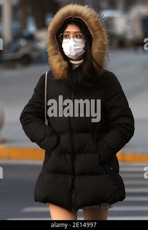 Peking, China. Januar 2021. Eine Chinesin trägt eine Gesichtsmaske, während sie am Montag, den 4. Januar 2021, durch ein Einkaufsviertel in Peking geht. Chinas Hauptstadt hat in der letzten Woche neue Covid-19-Fälle registriert, was die lokalen Behörden dazu veranlasste, einen "Notstand" auszurufen. Foto von Stephen Shaver/UPI Kredit: UPI/Alamy Live Nachrichten Stockfoto