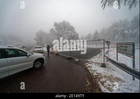 Hellenthal, Deutschland. Januar 2021. Besucher des Skigebiets "Weißer Stein" in der Eifel stehen vor einem Bauzaun, der den Zugang zu einem Parkplatz versperrt.nach einem großen Andrang am Wochenende hat die Gemeinde Hellenthal den Parkplatz gesperrt. Quelle: Henning Kaiser/dpa/Alamy Live News Stockfoto