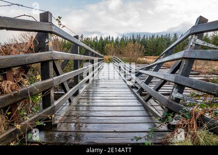 Eine alte, verfaulte Holzbrücke über den Fluss Owenea bei Ardara in der Grafschaft Donegal - Irland. Stockfoto