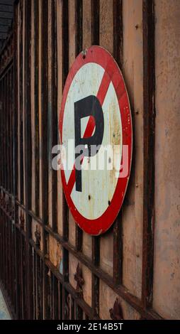 Woodstock- Cape Town, South Africa - 14/11/2020 Rusty 'No Parking' Schild an einem Tor auf der Albert Road. Menschen und fließender Verkehr im Hintergrund. Stockfoto