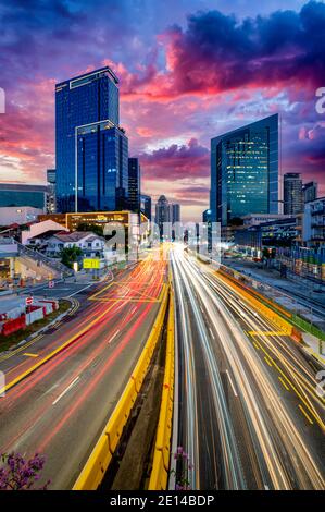 Leichte Wege gegen ikonische Gebäude und Infrastruktur bei Sonnenuntergang oder Abenddämmerung in Singapur Stockfoto