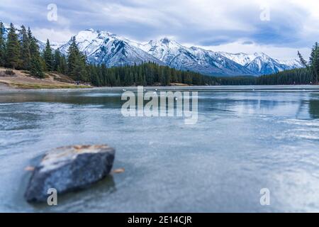 Johnson Lake gefrorene Wasseroberfläche im Winter. Schneebedeckter Berg im Hintergrund. Banff National Park, Kanadische Rockies, Alberta, Kanada. Stockfoto