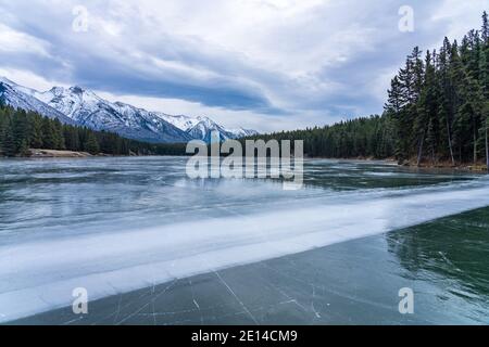 Johnson Lake gefrorene Wasseroberfläche im Winter. Schneebedeckter Berg im Hintergrund. Banff National Park, Kanadische Rockies, Alberta, Kanada. Stockfoto