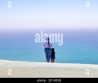 Signal Hill - Kapstadt, Südafrika - 02/12/2020 stilvolle südafrikanische Frau. Fotos von ihrer Freundin machen, die über den Ozean schaut. Stockfoto