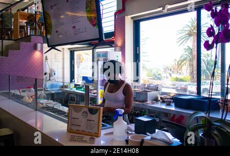 Mojo Markt- Kapstadt, Südafrika - 16/12/2020 netter und farbenfroher Imbissstand im Mojo Markt. Freundliche Angestellte mit Gesichtsmaske. Stockfoto