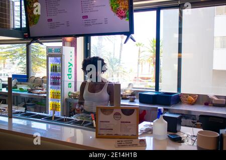 Mojo Markt- Kapstadt, Südafrika - 16/12/2020 netter und farbenfroher Imbissstand im Mojo Markt. Freundliche Angestellte mit Gesichtsmaske. Stockfoto