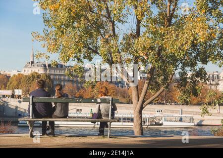 Machen Sie eine Pause auf der Parkbank und genießen Sie die Aussicht auf die seine an einem klaren, sonnigen Herbstnachmittag in Paris, Frankreich Stockfoto