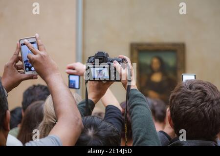 Paris, Frankreich - Oktober 24 2015: Touristenmassen tummeln sich aus nächster Nähe, um Fotos von Leonardo da Vincis Meisterwerk Mona Lisa im Louvre zu machen Stockfoto