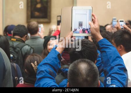 Paris, Frankreich - Oktober 24 2015: Touristenmassen tummeln sich aus nächster Nähe, um Fotos von Leonardo da Vincis Meisterwerk Mona Lisa im Louvre zu machen Stockfoto