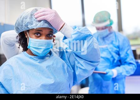 Erschöpfte Ärzte und Krankenschwestern mit Schutzkleidung in der Klinik während Covid-19 Pandemie Stockfoto