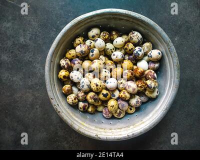 Wachteleier in Holzschale isoliert auf weißem Hintergrund Ausschnitt.Wachteleier in einem Nest auf einem rustikalen Holzhintergrund. Gesunde Ernährung Konzept. Stockfoto