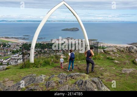 Morth, Vater und Kind an der Spitze von North Berwick Law, mit Replik Whalebones. Firth of Forth im Hintergrund Stockfoto